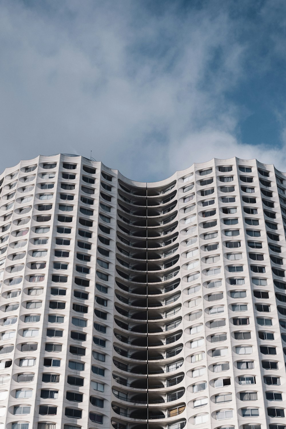 Weißes Betongebäude unter blauem Himmel tagsüber