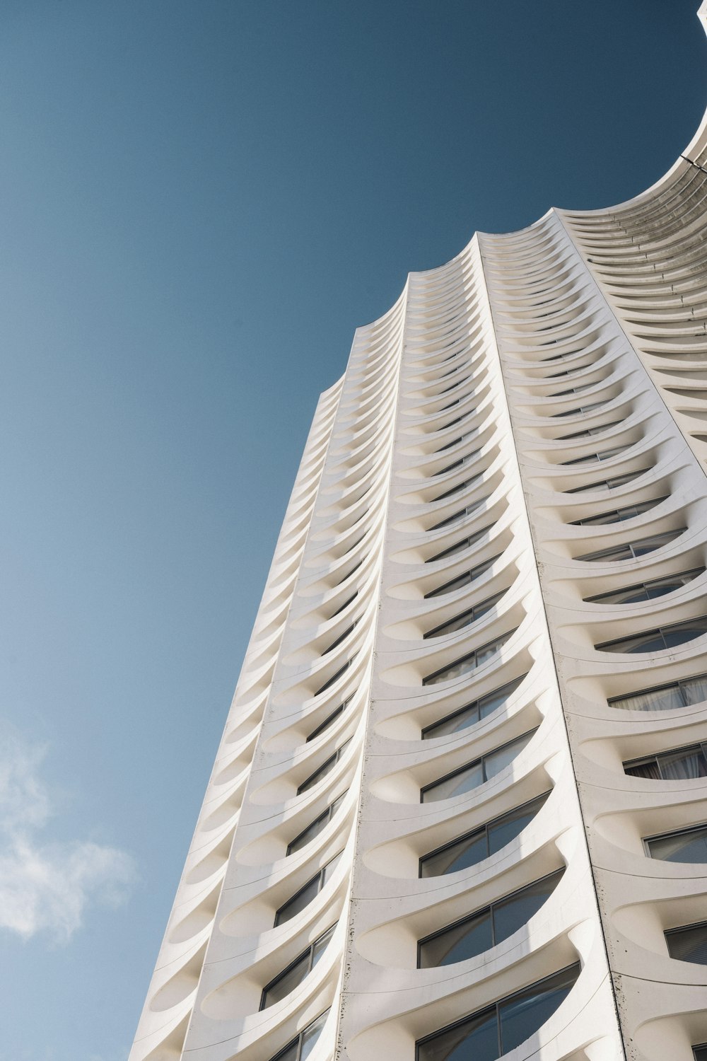 Weißes Betongebäude unter blauem Himmel tagsüber