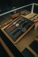 A collection of outdoor watches displayed on a wooden table.