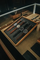 Close-up of elegant accessories like watches and bracelets arranged neatly on a wooden table