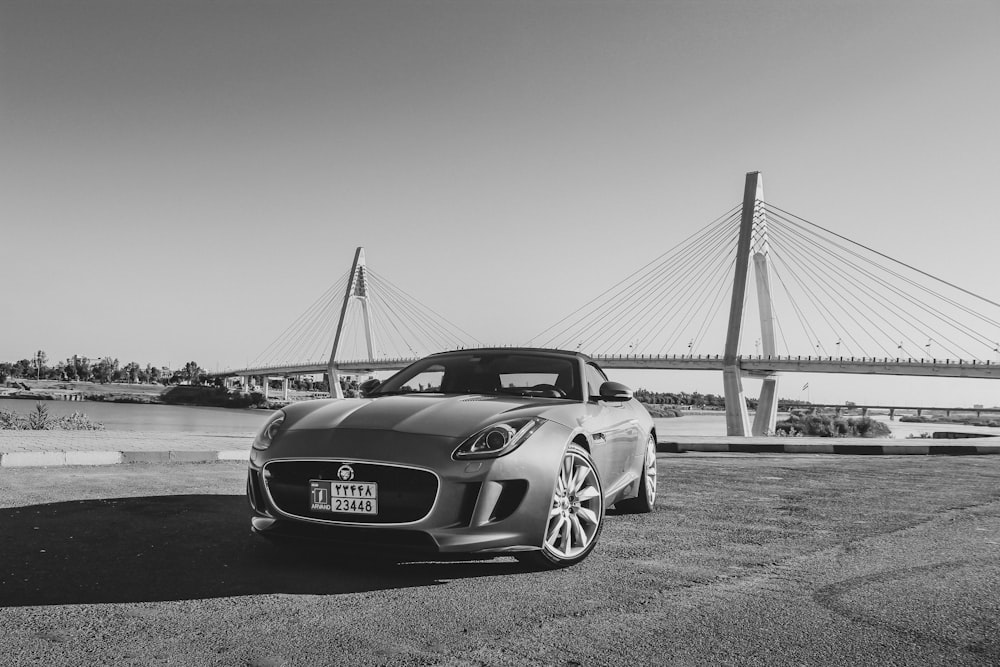 grayscale photo of mercedes benz coupe on bridge