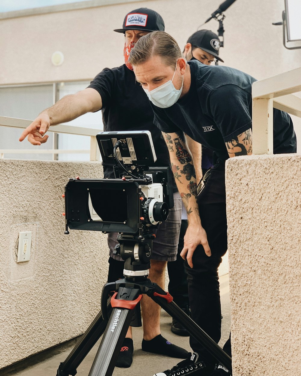 man in black t-shirt holding black dslr camera