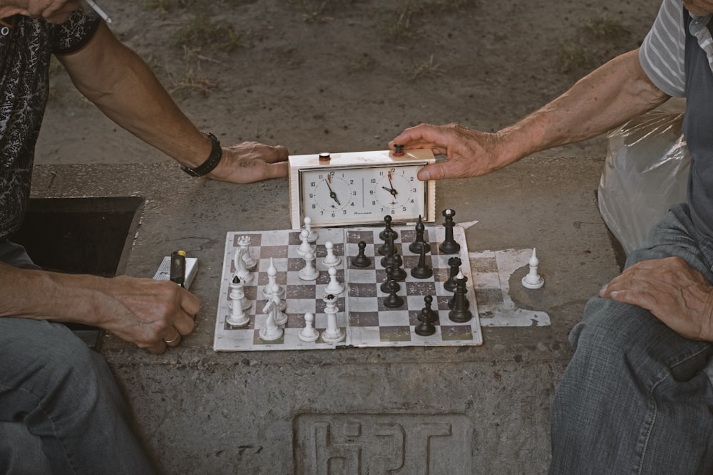 person playing chess on gray concrete floor