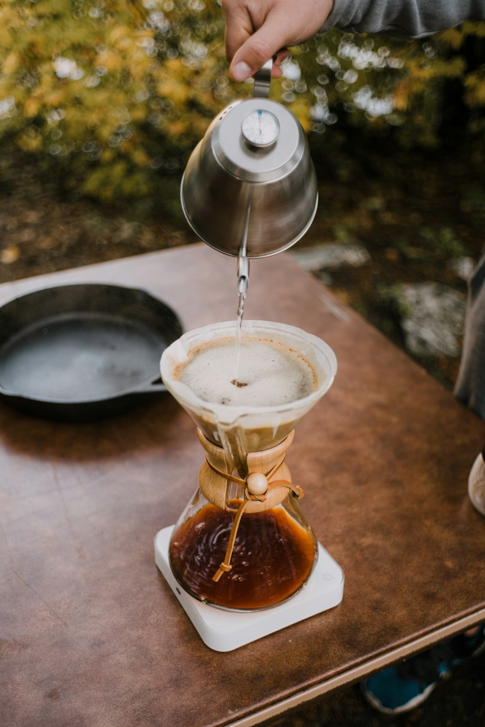 clear glass cup with brown liquid on brown wooden table