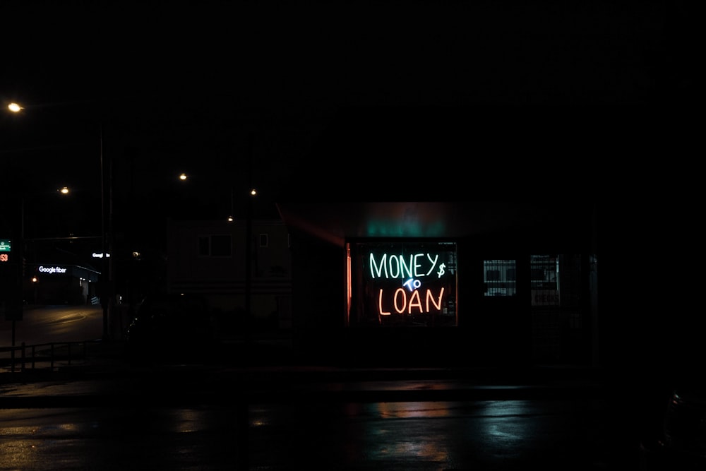 a neon sign is lit up in the dark