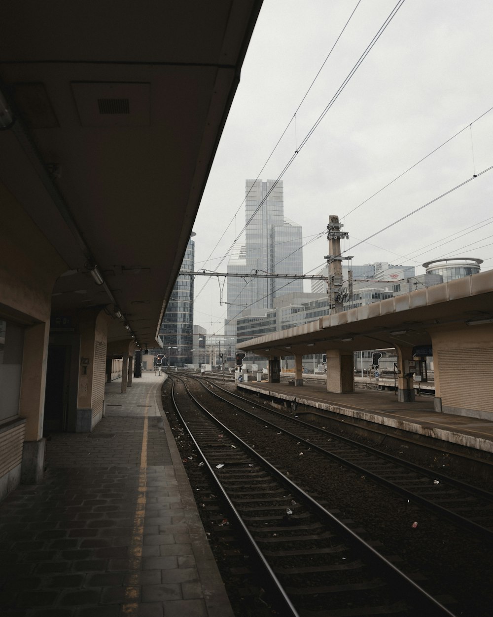 train rail under white sky during daytime