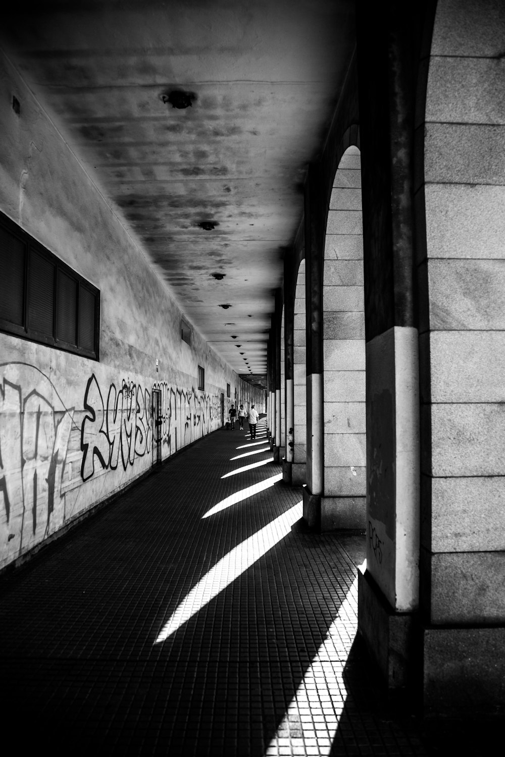 grayscale photo of concrete hallway