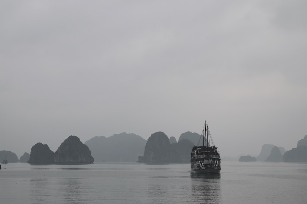 black boat on sea under white sky during daytime