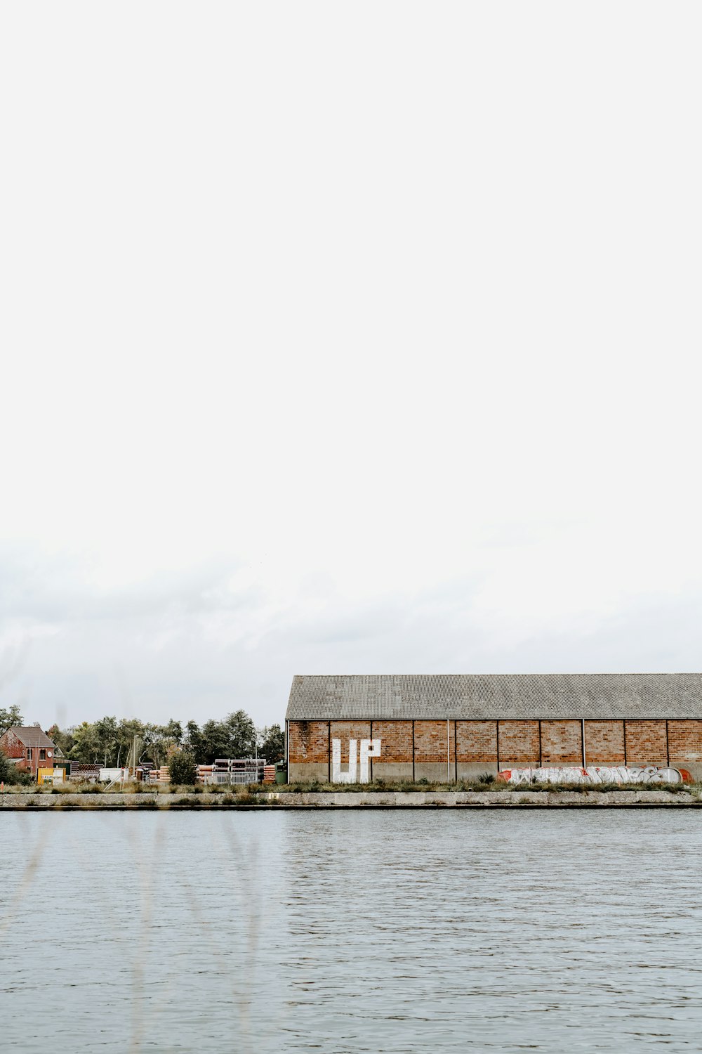 edifício de concreto marrom e cinza perto do corpo de água durante o dia