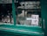 A storefront window displays various crystal glasses arranged neatly inside. A handwritten sign with the text 'Black Lives Matter' is taped to the glass. The window frame is painted in a worn green color.