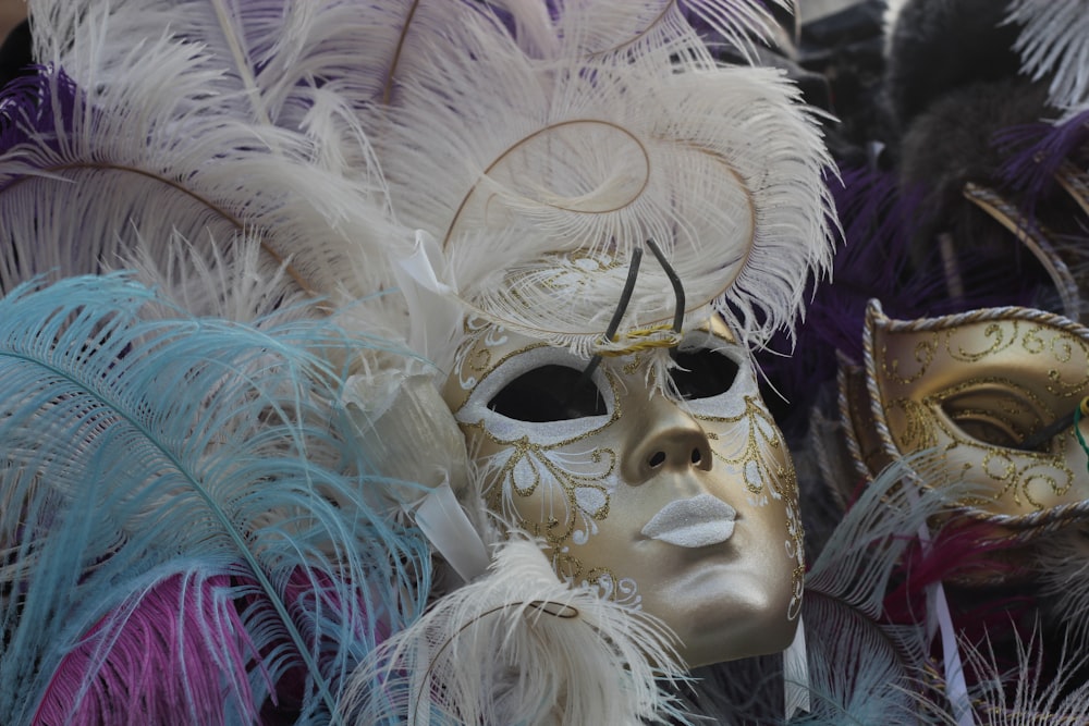 Máscara de plumas blancas y moradas