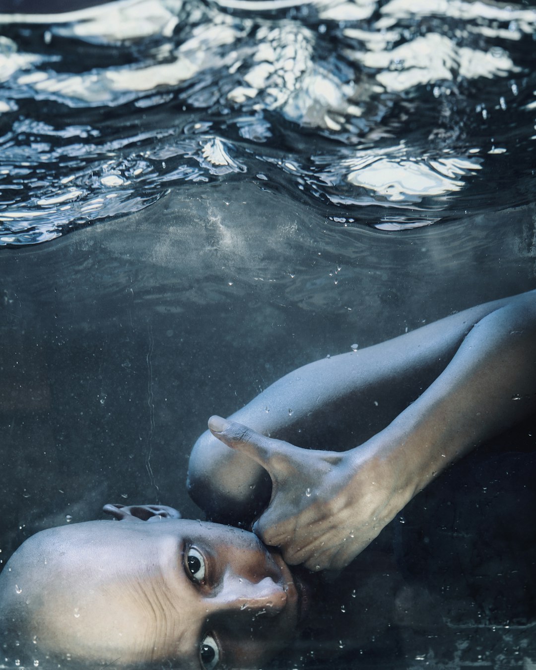 woman in blue and white bikini lying on water