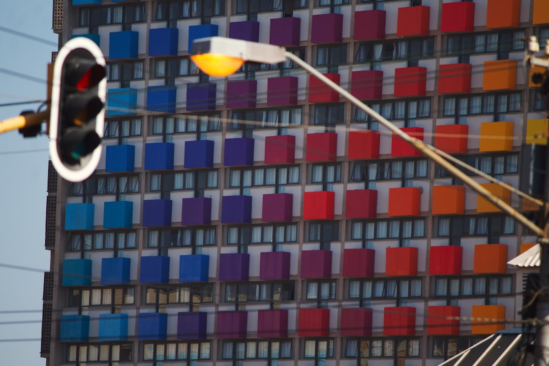 person holding yellow umbrella near brown concrete building during daytime