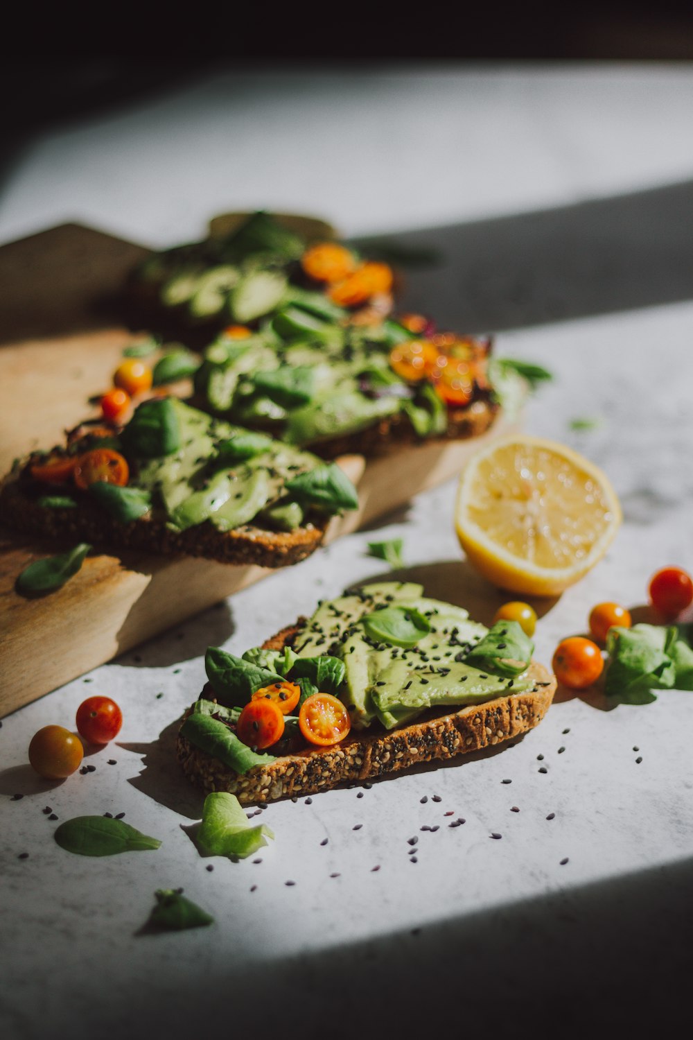 Pain tranché aux légumes verts et citron tranché sur assiette en céramique blanche