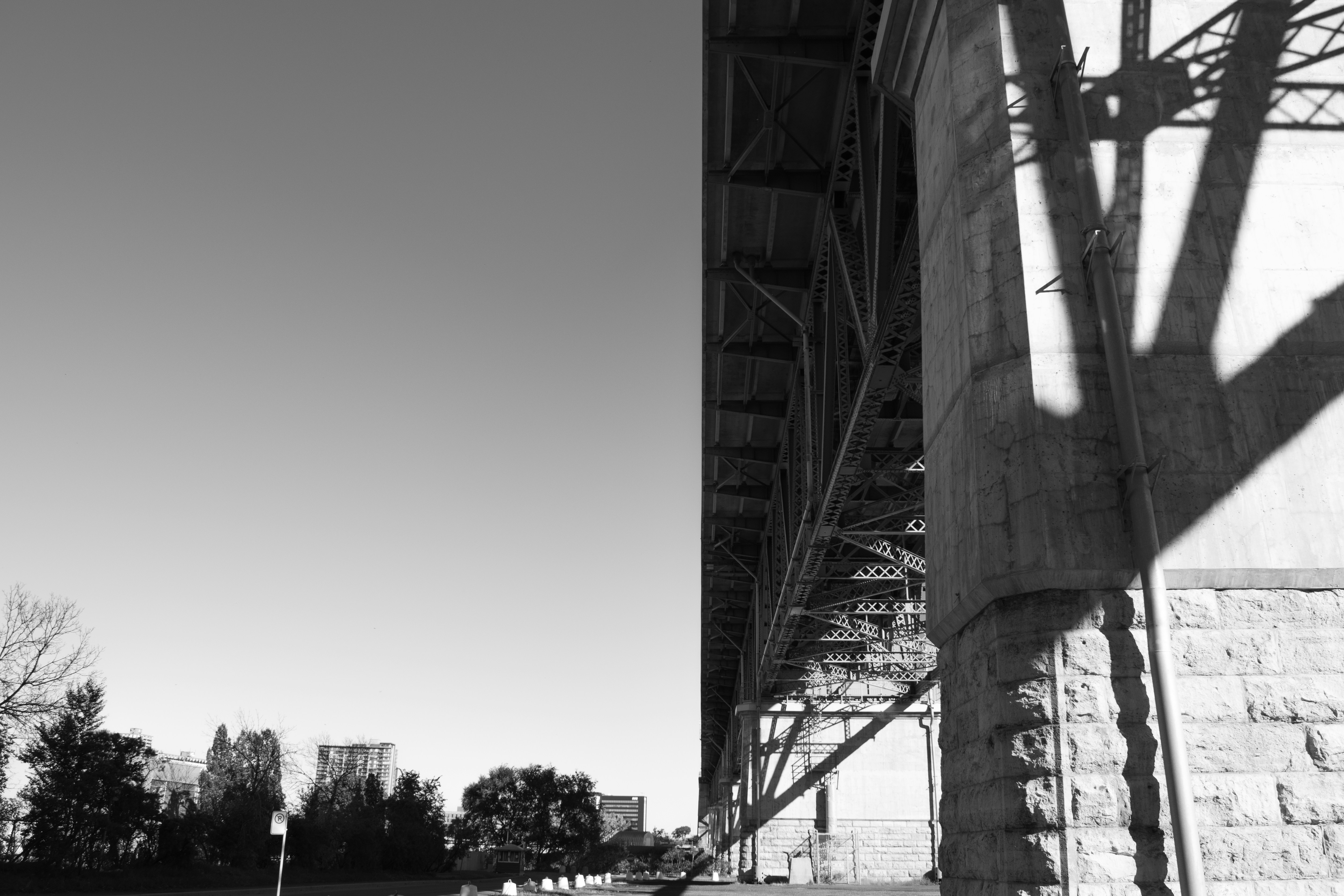 grayscale photo of bridge under cloudy sky