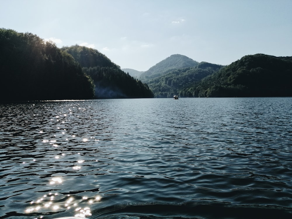 body of water near mountain during daytime