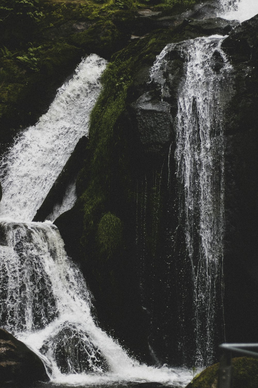 cachoeiras no meio de rochas cobertas de musgo verde