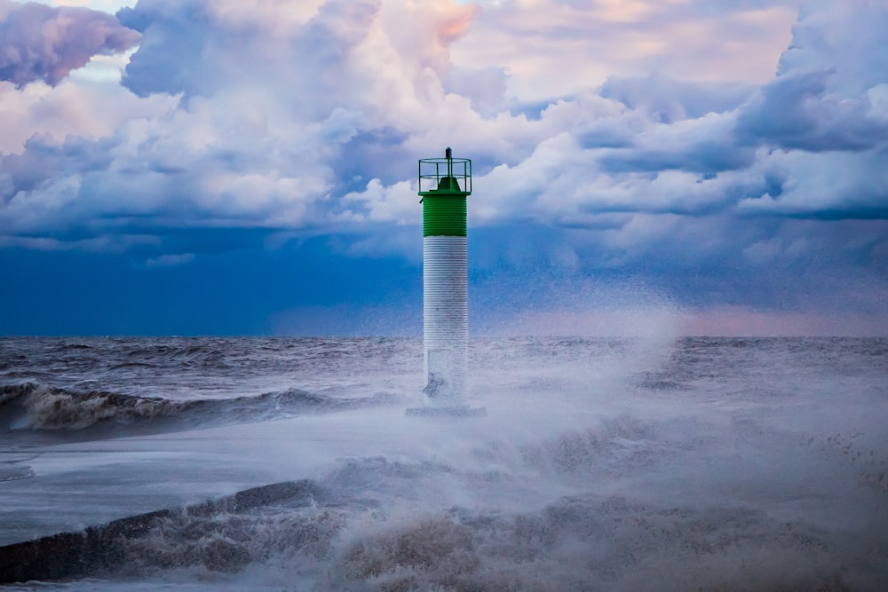 white and green lighthouse on white clouds during daytime