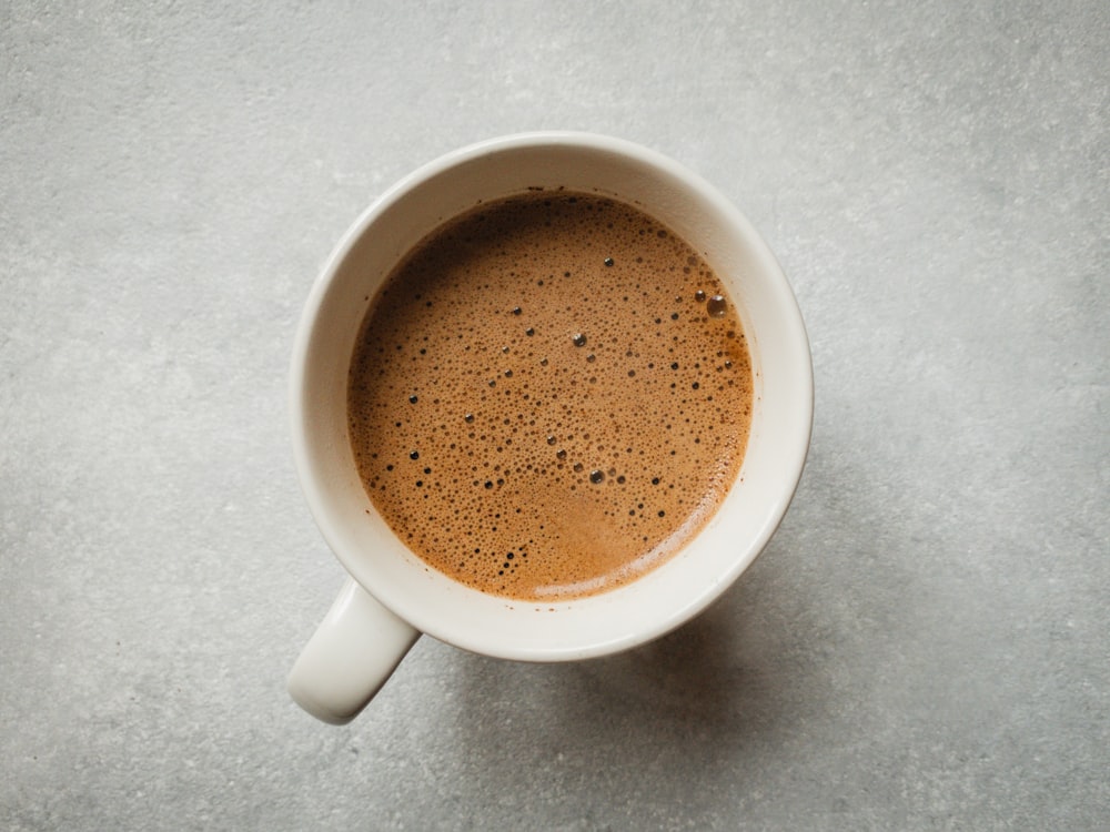 white ceramic mug with brown liquid