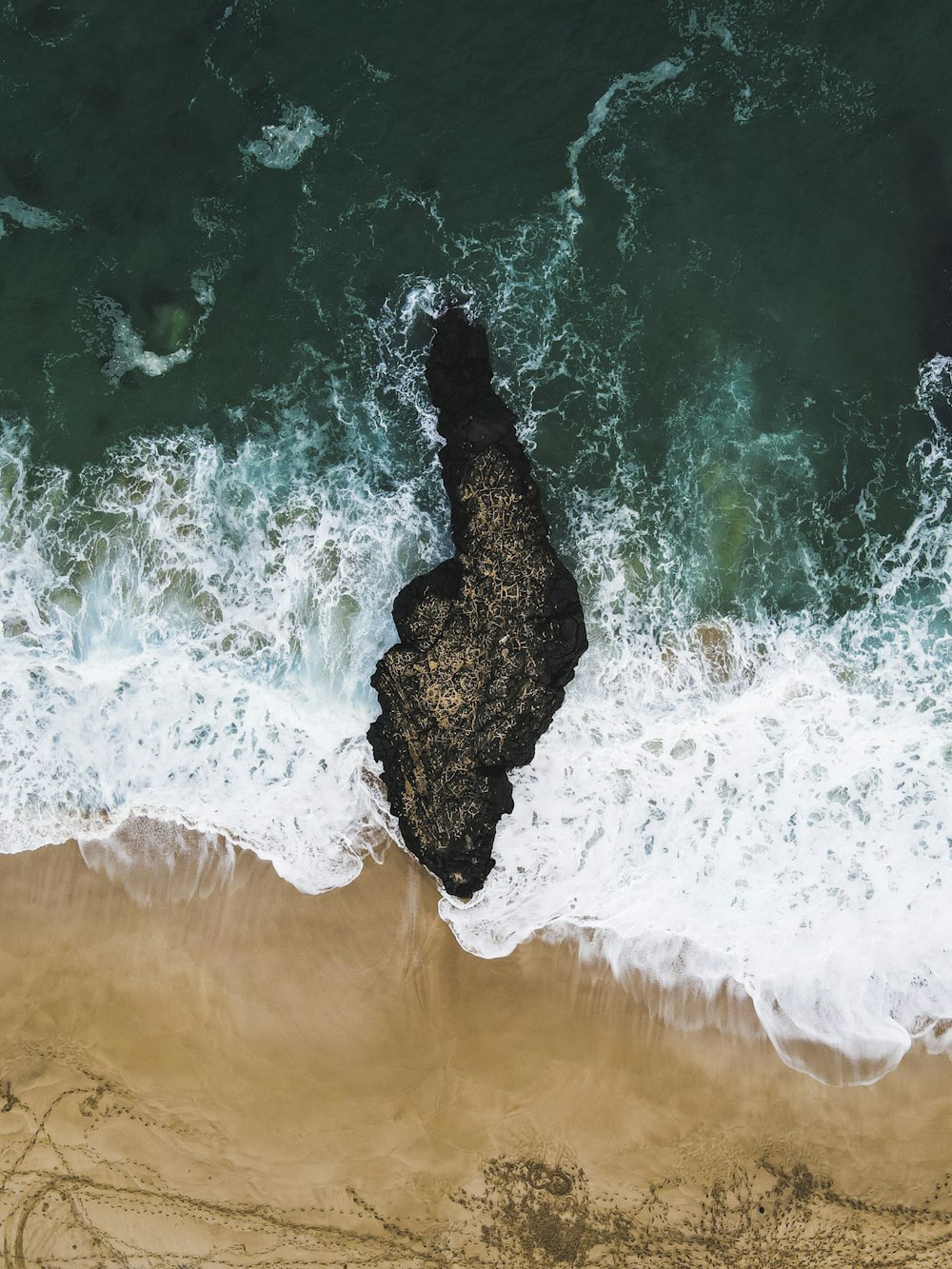 black rock formation on body of water