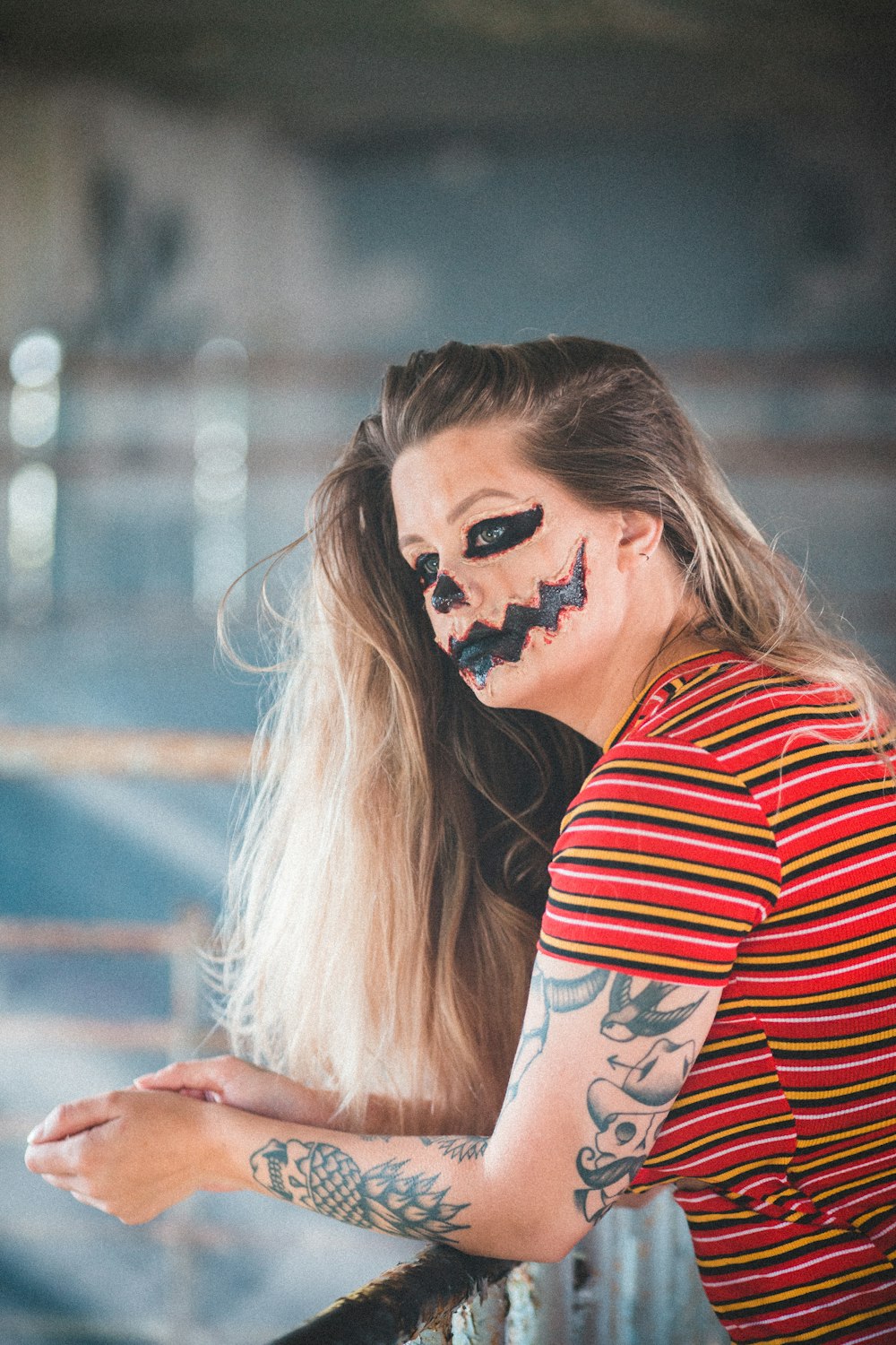 woman in red and white striped shirt with black face paint