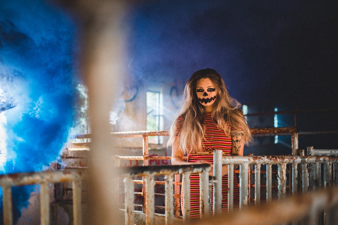 woman in red long sleeve shirt standing on brown wooden fence