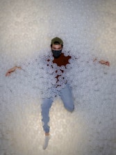 A smiling person relaxing inside a transparent hyperbaric oxygen capsule.