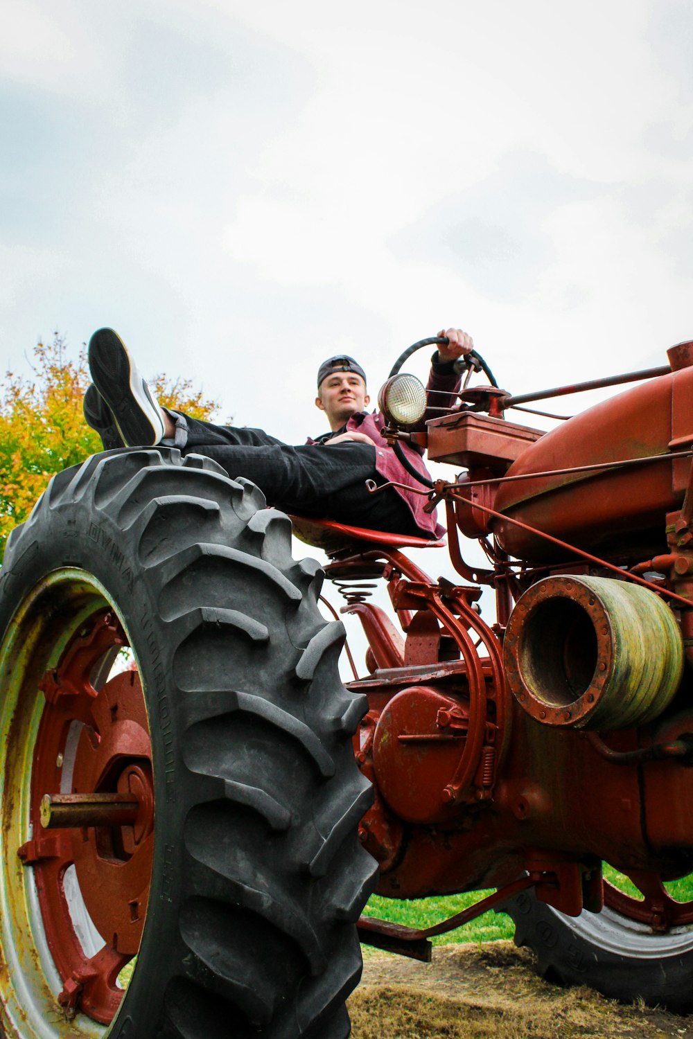man in black jacket riding red tractor