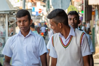 man in white polo shirt standing beside boy in white polo shirt