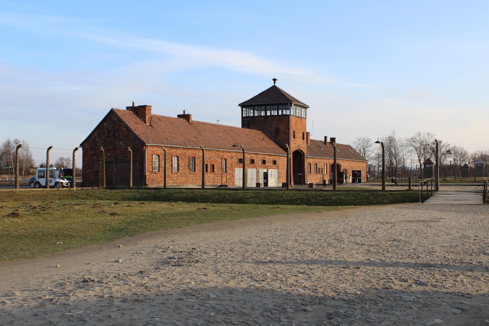 brown brick building near bare trees under blue sky during daytime