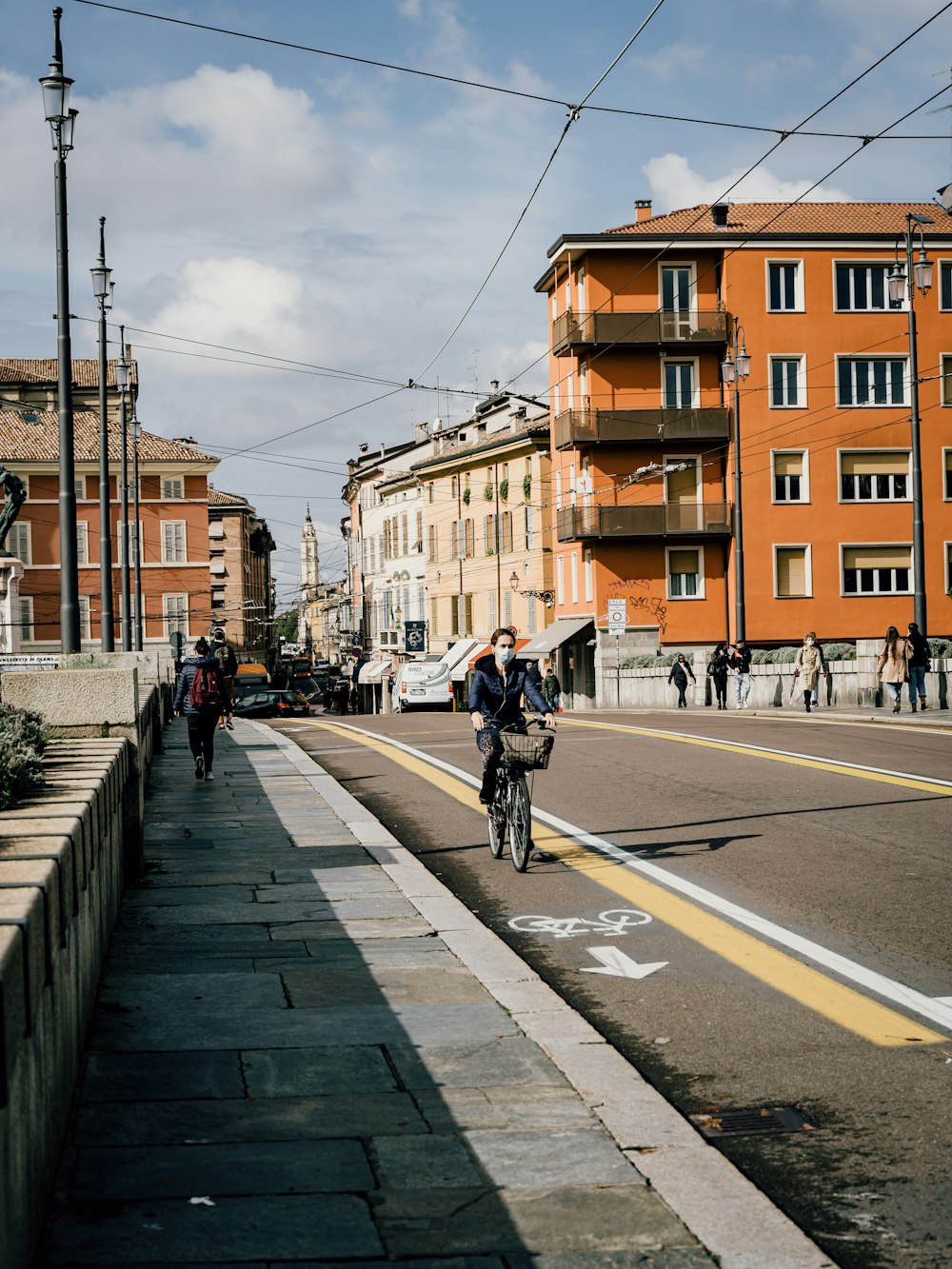 man in black jacket riding bicycle on road during daytime