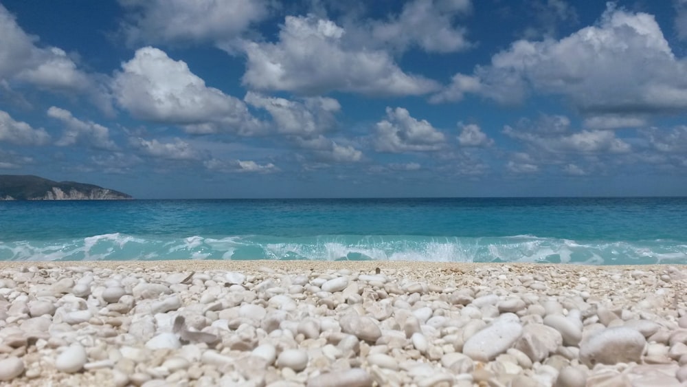 white sand beach under blue sky and white clouds during daytime