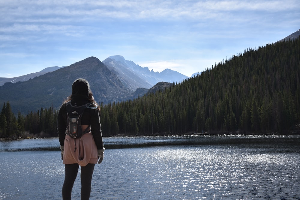 woman in black jacket standing on lake during daytime