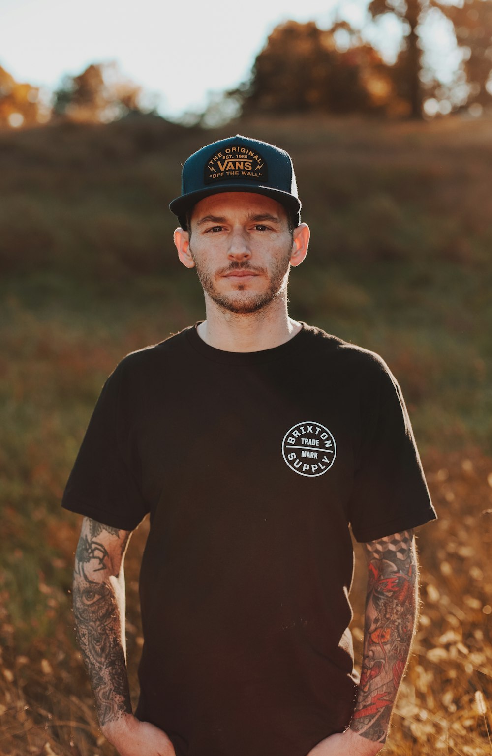 man in black crew neck t-shirt wearing black cap