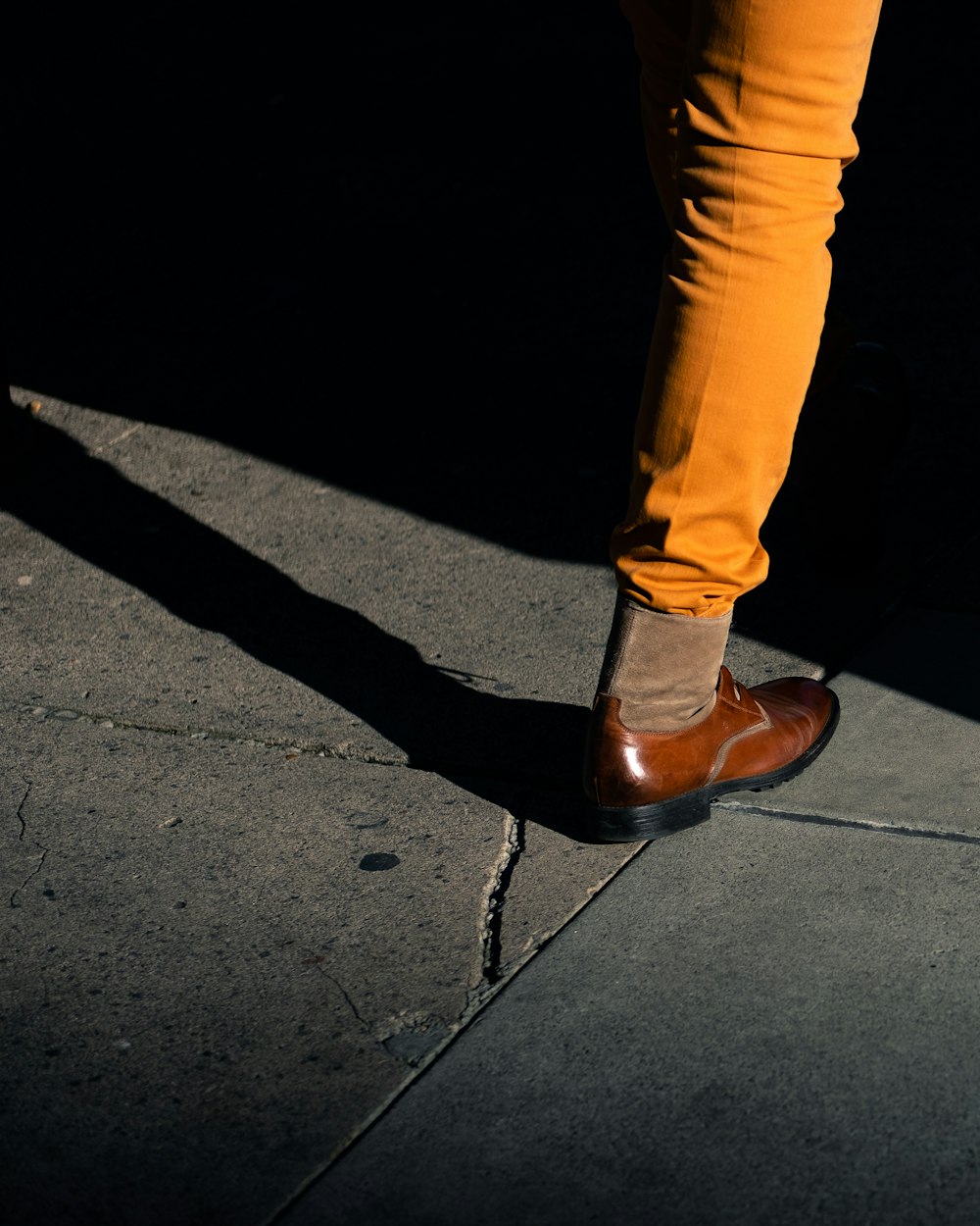 person in brown pants and brown leather boots