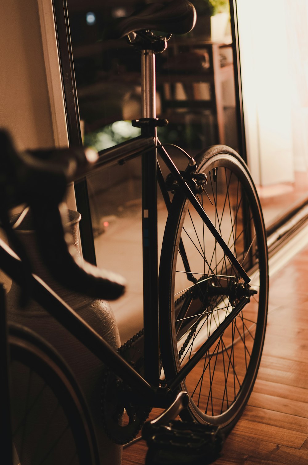 grayscale photo of bicycle near window