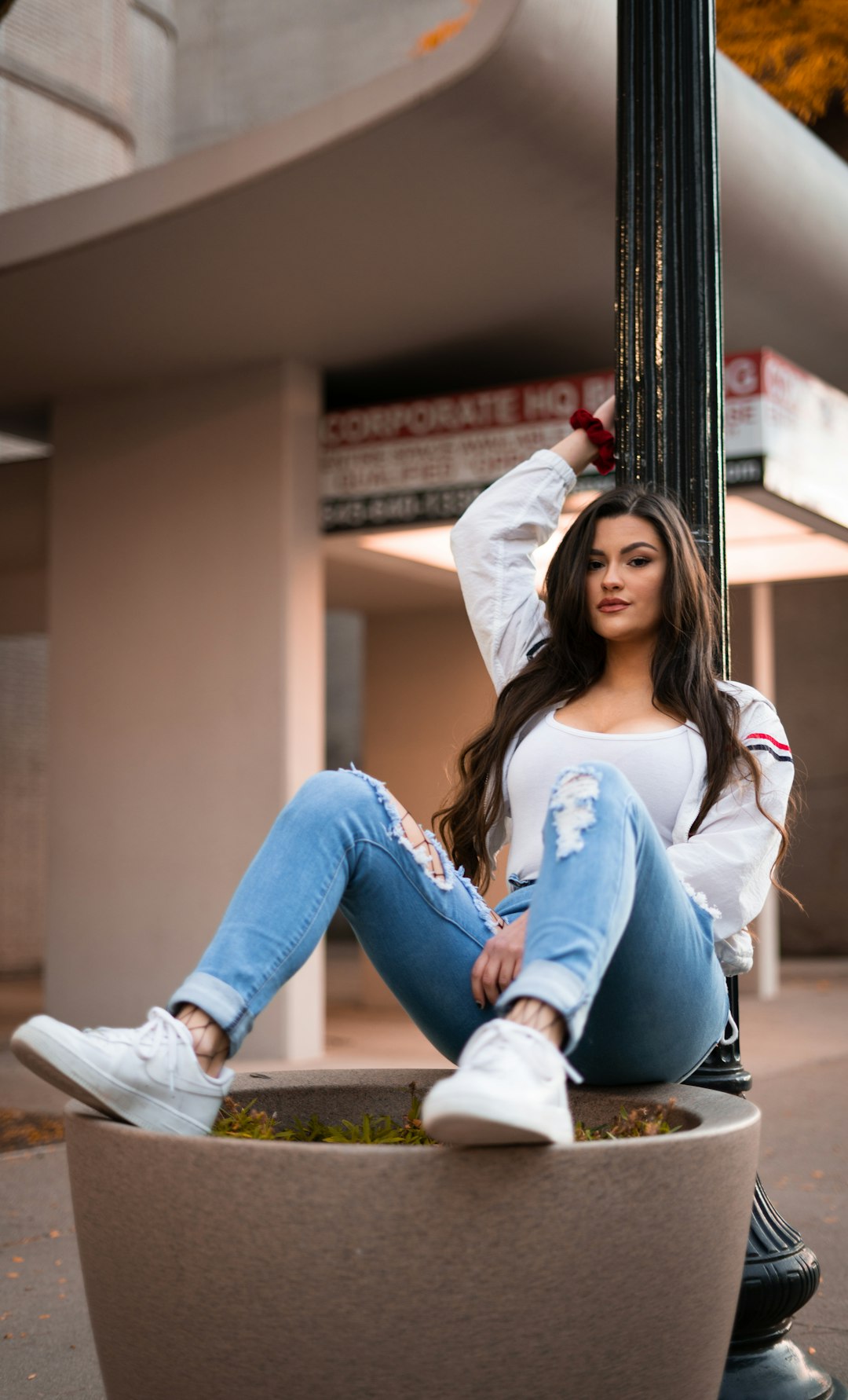 woman in blue denim jeans sitting on brown wooden bench