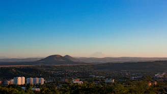 A scenic aerial view of Pereira city with mountains in the background under a clear sky.