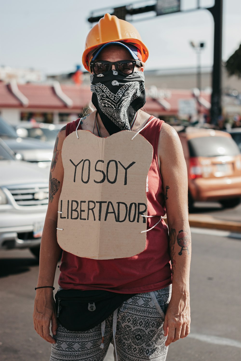 woman in red tank top wearing black and white mask