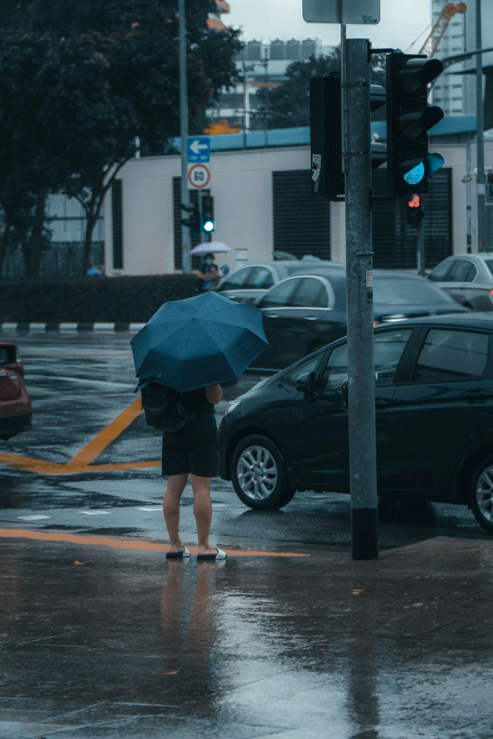 woman in black jacket and blue denim shorts walking on pedestrian lane during daytime