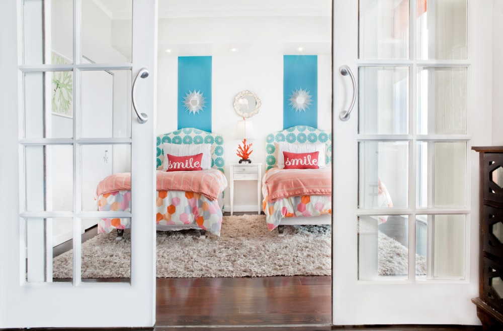 white wooden framed bed with orange and white pillows