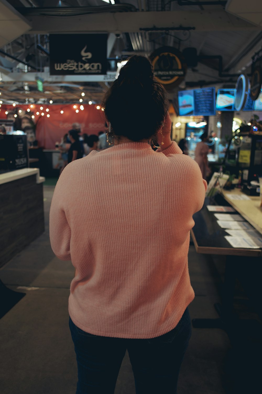 woman in white knit sweater standing in front of counter