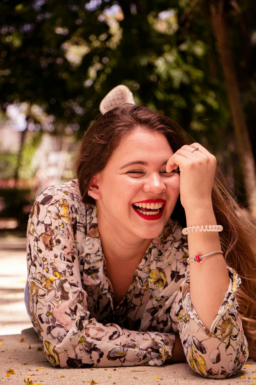 woman in white blue and brown floral shirt smiling