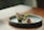 Elegant plating of a classic Ecuadorian dish with a modern minimalist restaurant backdrop.