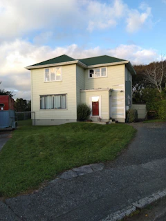 Star Renovations crew installing new yellow siding on a cozy suburban home.