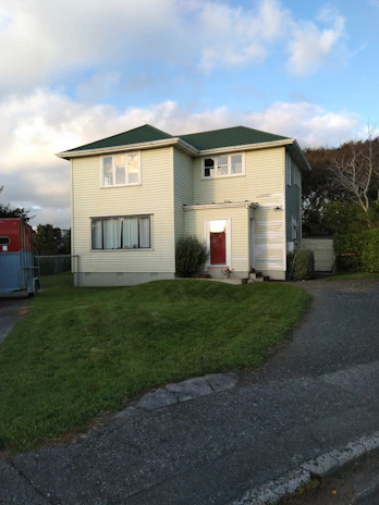 Star Renovations crew installing new yellow siding on a cozy suburban home.