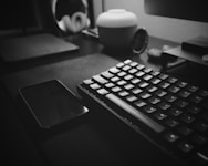 A sleek black and white photo of a minimalist office desk with accounting tools neatly arranged.