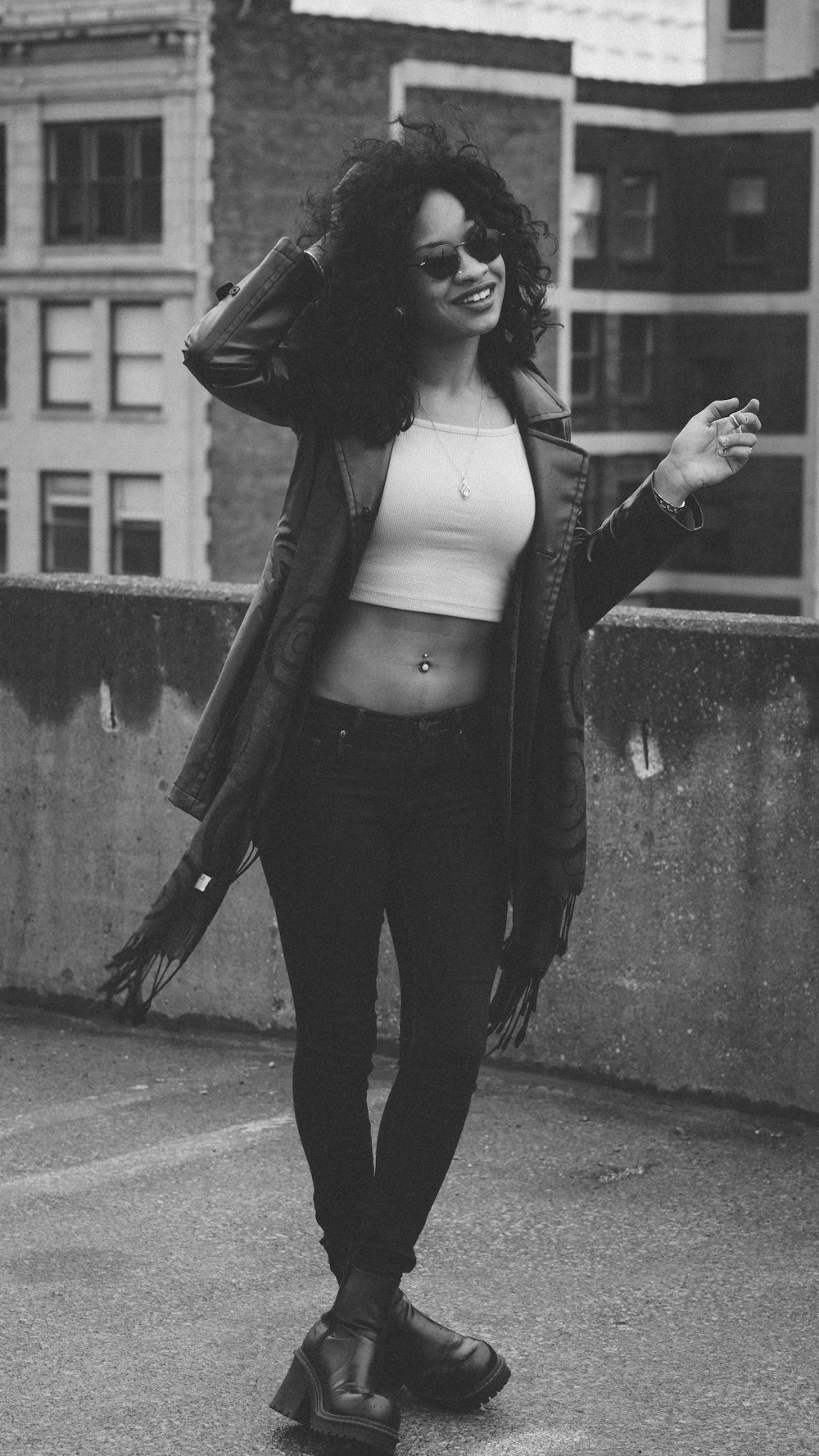 woman in black jacket and black pants standing on sidewalk