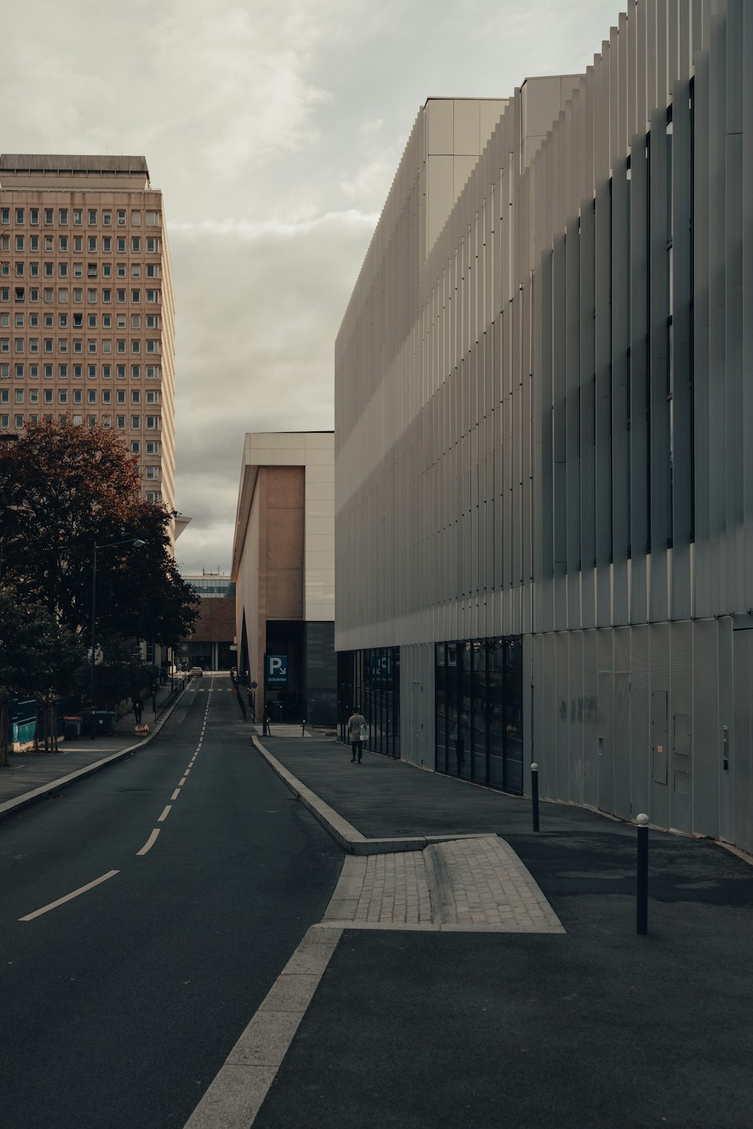 gray concrete road between high rise buildings during daytime