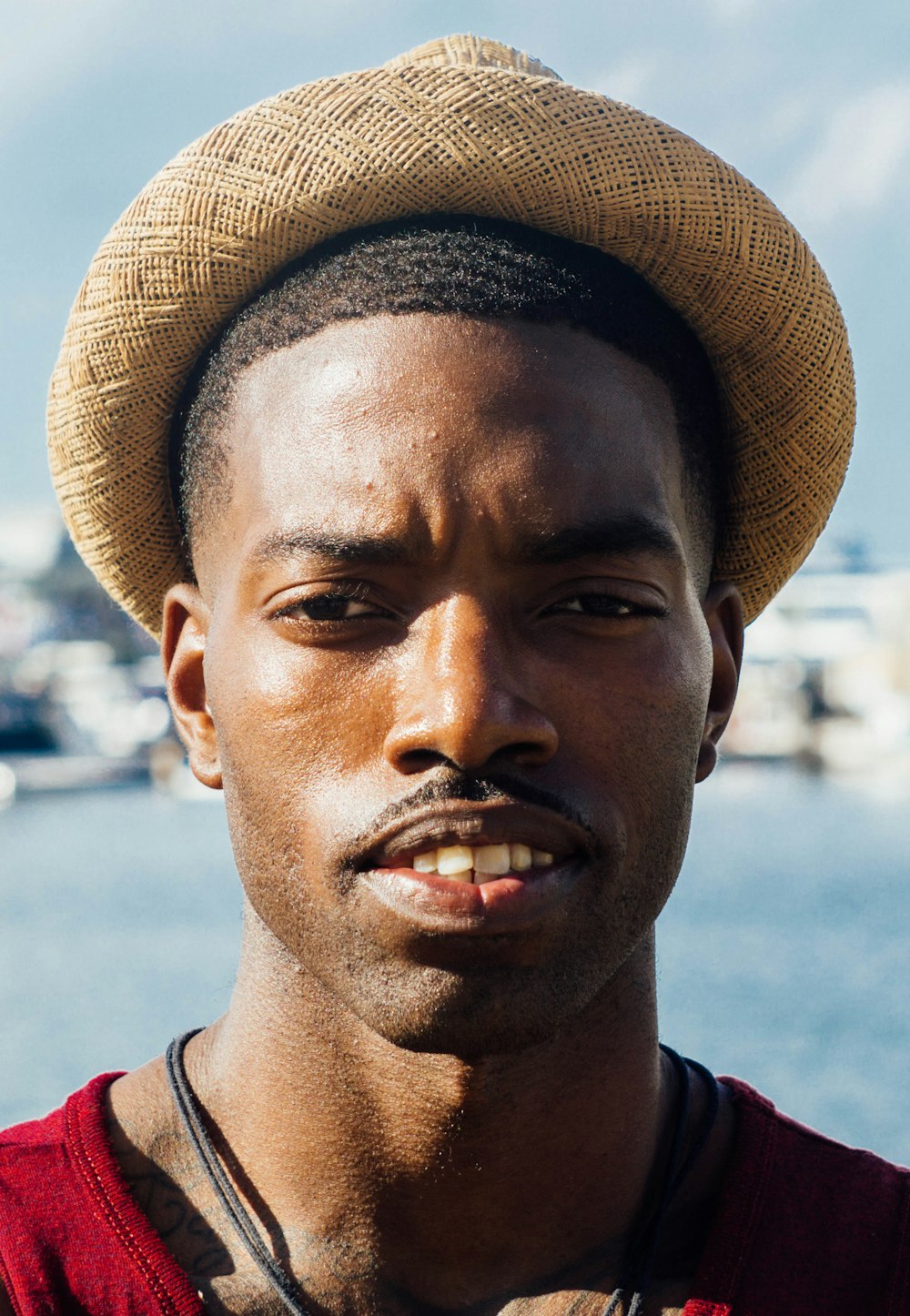 man in red and white shirt wearing brown fedora hat